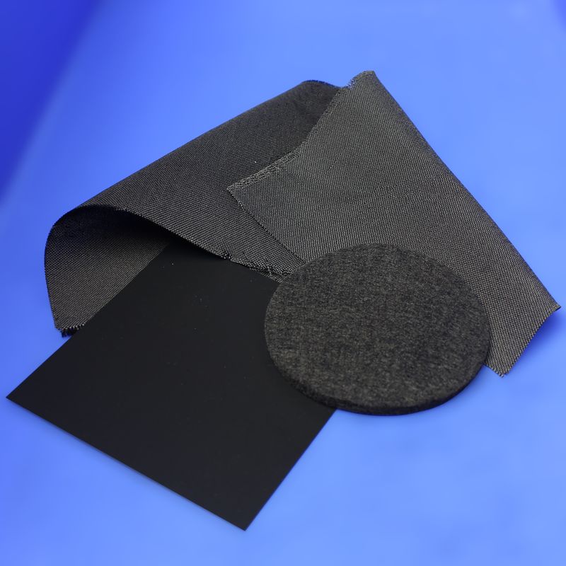 Sheets and discs of black gas diffusion layer carbon paper on a blue background